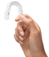 Hand holding Invisalign Aligner